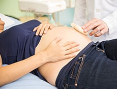 Closeup of a young pregnant woman in a hospital bed while getting an ultrasound
